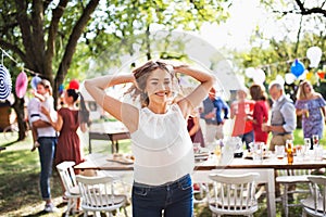 A teenage girl on a family celebration or a garden party outside.