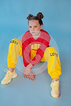 teenage girl in fashion stylish bright clothes. little lady in red and yellow on blue background. makeup and hairdo