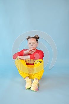 teenage girl in fashion stylish bright clothes. little lady in red and yellow on blue background. makeup and hairdo