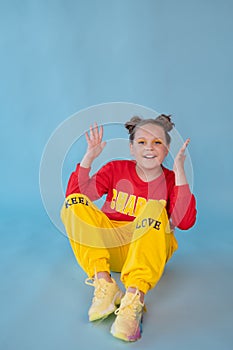 teenage girl in fashion stylish bright clothes. little lady in red and yellow on blue background. makeup and hairdo