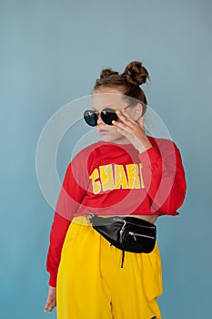 teenage girl in fashion stylish bright clothes. little lady in red and yellow on blue background. makeup and hairdo