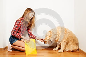 Teenage girl feeding her Golden Retriever doggy