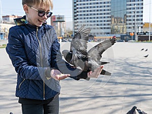 teenage girl feeding pigeons in the square