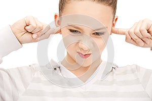 Teenage girl with fingers in ears