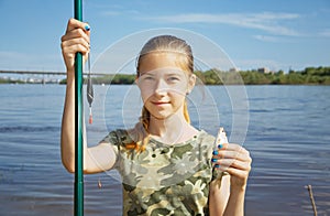 A teenage girl on a fishing trip against a cityscape background