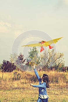 Teenage girl flying a yellow kite. Beautiful young girl kite fly. Happy little girl running with kite in hands on the
