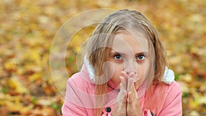 Teenage girl freezes in the autumn park.