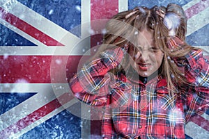 Teenage girl on frozen background with flag of Great Britan. Concept of crisis in Europe in winter. Energy crisis