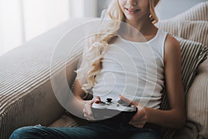 Teenage girl with game controller plays video game.