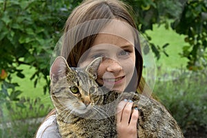 Cute teenage girl cuddles  with her cat photo