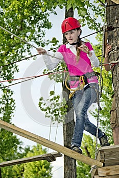 A teenage girl goes on hinged trail in extreme rope park