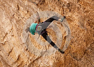 A teenage girl grips the ridges of the limestone formation known as the Cathedral cave in Southern Utah while rock climbing