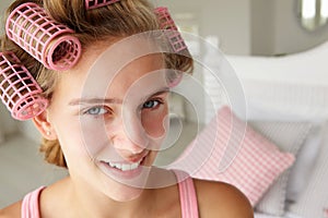 Teenage girl with hair in pink curlers