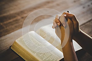 Teenage girl hand with Bible praying in the morning