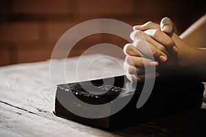 Teenage girl hand with Bible praying in the morning