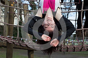 Teenage Girl Hanging Upside Down on Jungle Gym
