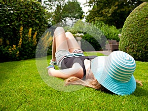 Teenage Girl with a hat covering her face lying on her back