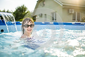 teenage girl having fun in outdoor pool. Child learning to swim. Kid having fun with water toys. Family fun in a pool