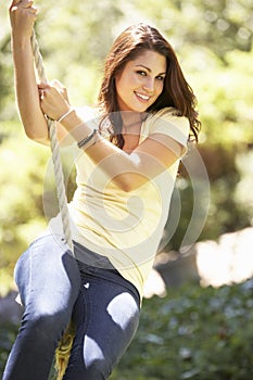 Teenage Girl Having Fun On Rope Swing