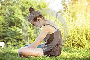 Teenage girl hears music in a garden photo