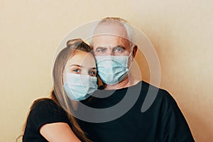 Teenage girl help grandfather and support during pandemic, looks at camera leaning on his shoulder. .granddaughter worry about sen