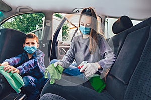 Teenage girl and her brothers cleaning the car with mask