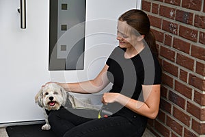 Teenage girl and her dog  waiting in front of a door