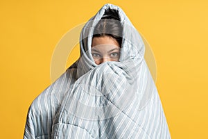 Teenage girl hid in gray blanket. Concept of sweet sleep, dreams, scary horror stories, daydreams photo