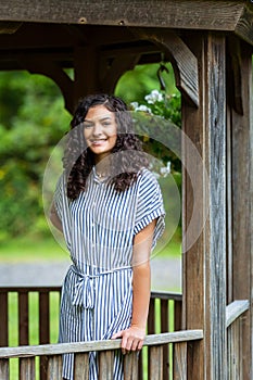 Teenage girl high school senior in striped dress at gazebo