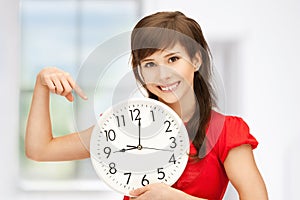 Teenage girl holding big clock