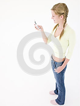 Teenage girl holding cellular phone and smiling