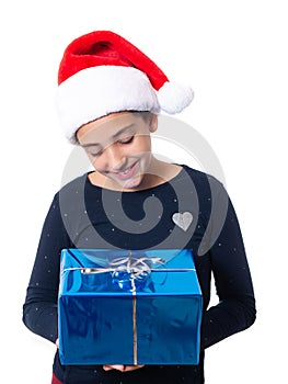 Teenage girl holding a Christmas present and wearing a Santa hat