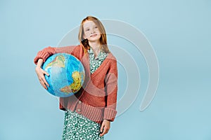 Teenage girl holding planet earth globe under her arm
