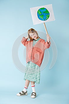 Teenage girl holding planet earth sign in support of zero waste movement