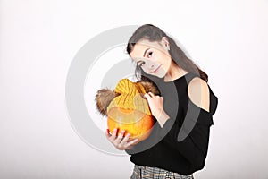 Teenage girl holding pumpkin in yellow cap with bobbles