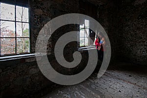 Teenage girl holding a toy  doll in an abandoned room . Lonely people