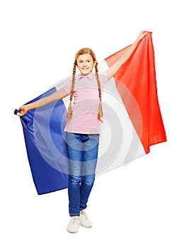 Teenage girl holding unfolded French flag behind