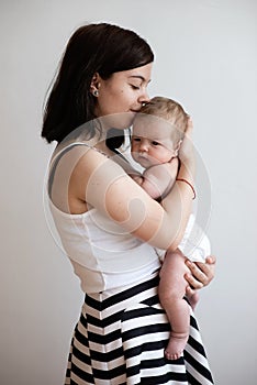 A teenage girl holds her little younger sister in her arms, tender hugs, kindred feelings.