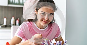 Teenage girl holds silver spoon with soup and smiles