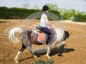 Teenage girl on horseback wearing helmet