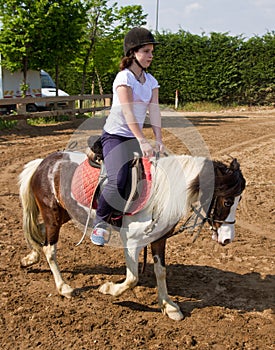 Teenage girl on horseback wearing helmet