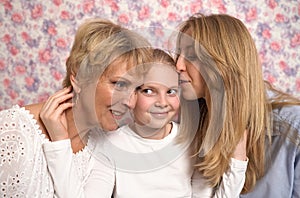 A teenage girl hugs her grandmother and mother, expresses her love to them