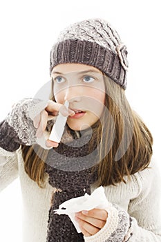Teenage girl injecting drops into the nose. photo