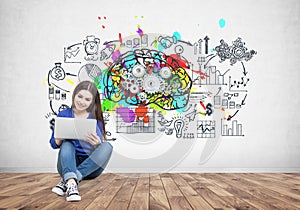 Teenage girl in jeans holding a laptop, brain cogs