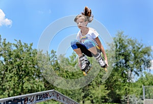 Teenage girl jumping in the air on rollerblades