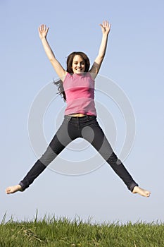 Teenage Girl Jumping in Summer Meadow