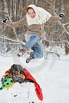 Teenage girl jumps over burning stuffed Maslenitsa