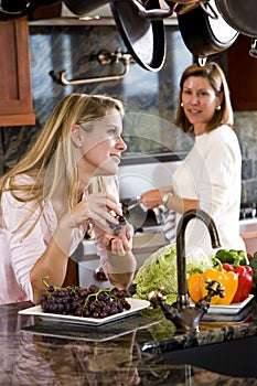 Teenage girl in kitchen chatting with mother