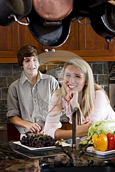 Teenage girl in kitchen with younger brother