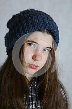 Teenage girl in knitted blue hat with pompom